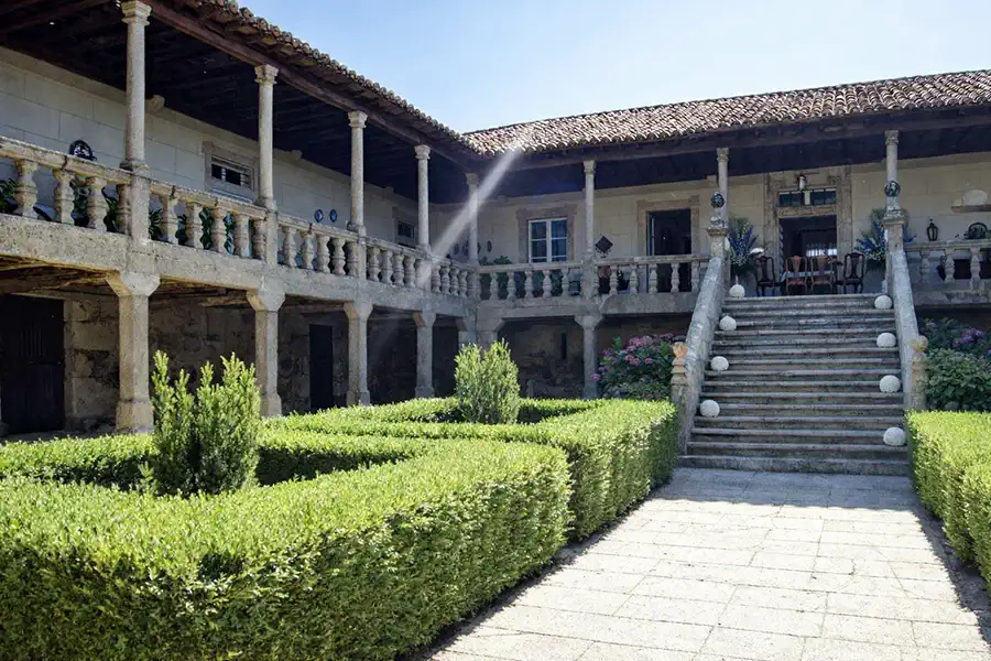 Facciata in granito e pianta a U del pazo galiziano.